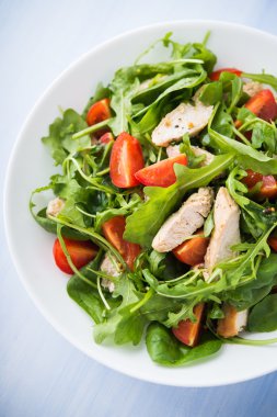 Fresh salad with chicken, tomato and greens (spinach, arugula)