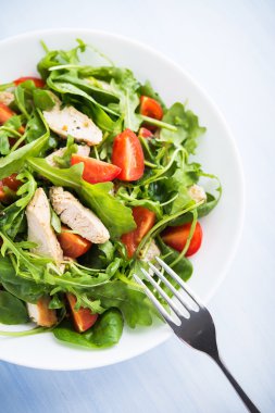 Fresh salad with chicken, tomato and greens (spinach, arugula)