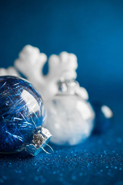 Ornamenti natalizi bianchi e blu su sfondo glitter blu scuro con spazio per il testo. Buon Natale, cartolina. Vacanze invernali. Tema di Natale. Felice anno nuovo . — Foto Stock