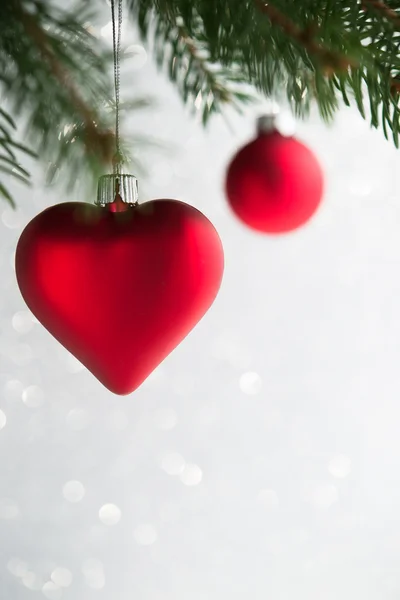 Enfeites de Natal vermelho (coração e bola) na árvore de xmas no fundo do bokeh brilho. Férias de inverno tema . — Fotografia de Stock