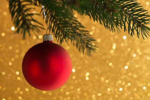 Rote dekorative Kugel auf dem Weihnachtsbaum auf glitzerndem Bokeh-Hintergrund. Frohe Weihnachten. Thema Winterurlaub. — Stockfoto