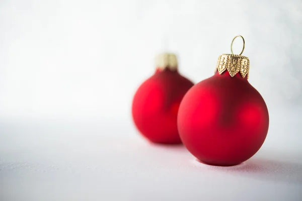 Červené vybavuju ornamenty na pozadí třpytu. Zimní svátky. Téma Xmas. Šťastný nový rok. — Stock fotografie