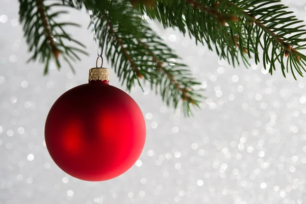 Červený dekorativní míč na stromě vybavuju na třpyt ' na pozadí. Veselý vánoční přání. Zimní prázdninové téma. — Stock fotografie