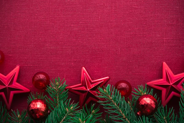 Marco con árbol de Navidad y adornos sobre fondo de lona roja. Feliz tarjeta de Navidad. Tema de vacaciones de invierno. Feliz Año Nuevo . —  Fotos de Stock