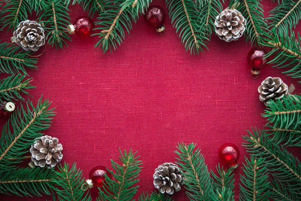 Cornice con albero di Natale e ornamenti su sfondo rosso tela. Buon Natale, cartolina. Tema vacanze invernali. Felice anno nuovo . — Foto Stock