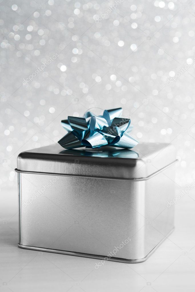 Metal gift box on white glitter background. Merry christmas card. Winter holidays. Xmas theme. Happy New Year.