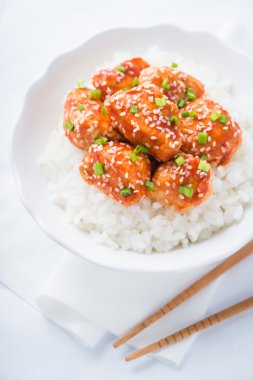 Baharatlı tatlı ve ekşi tavuk susam ile ve yakın kadar beyaz arka plan üzerinde pirinç. Oryantal gıda.