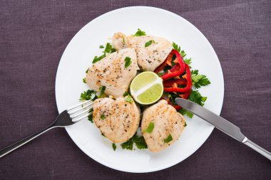 Koyu tuval arka plan maydanoz ve narenciye üst görünümü ile Tavuk göğüsler. Sağlıklı gıda.