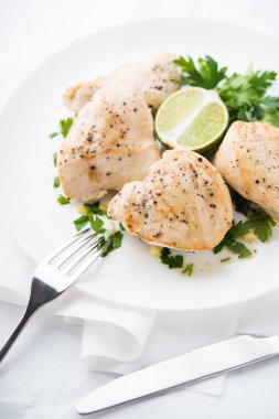 Beyaz arka planda maydanoz ve narenciye ile Tavuk göğüsleri yakın. Sağlıklı gıda.