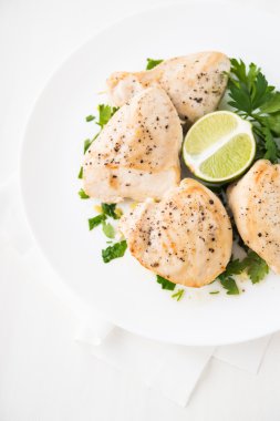 Beyaz arka plan üst görünümümaydanoz ve narenciye ile Tavuk göğüsler. Sağlıklı gıda.