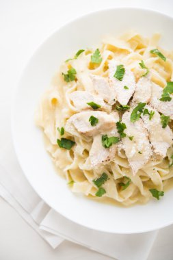 Tavuk, parmesan ve beyaz arka plan üstten görünüm üzerinde maydanoz ile makarna fettuccine alfredo. İtalyan mutfağı.
