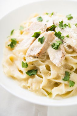 Makarna fettuccine alfredo tavuk, parmesan ve beyaz zemin üzerine maydanoz ile kapatın. İtalyan mutfağı.