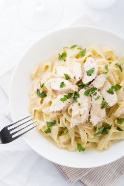Tavuk, parmesan ve beyaz arka plan üstten görünüm üzerinde maydanoz ile makarna fettuccine alfredo. İtalyan mutfağı.