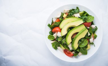 Taze salata tavuk, domates, ıspanak ve beyaz arka plan üstten görünüm üzerinde avokado. Sağlıklı gıda.