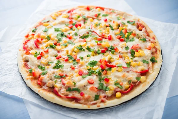 Pizza with mozzarella cheese, chicken, sweet corn, sweet pepper and parsley. Italian cuisine.