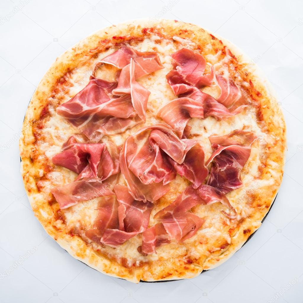 Pizza with prosciutto (parma ham) on white background top view. Italian cuisine.