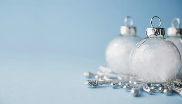 Hite adornos de Navidad sobre fondo azul claro. Feliz tarjeta de Navidad . —  Fotos de Stock