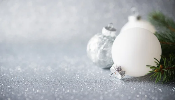 Adornos de Navidad plateados y blancos sobre fondo de fiesta de brillo. Feliz tarjeta de Navidad . —  Fotos de Stock