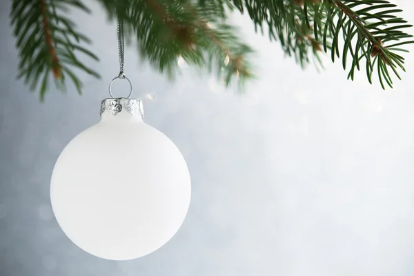 Biała świąteczna piłka na choince na błyszczącym tle bokeh — Zdjęcie stockowe