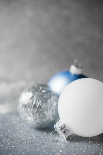 Ornamenti natalizi blu, argento e bianco su sfondo glitter vacanza — Foto Stock