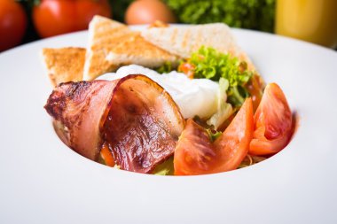 Ahşap arka plan üzerinde yumurta, domates, pastırma ve marul ile taze salata yakın