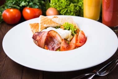 Ahşap arka plan üzerinde yumurta, domates, pastırma ve marul ile taze salata yakın