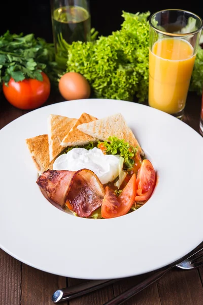 Свіжий салат з яйцем, помідорами, беконом і салатом на дерев'яному фоні крупним планом — стокове фото