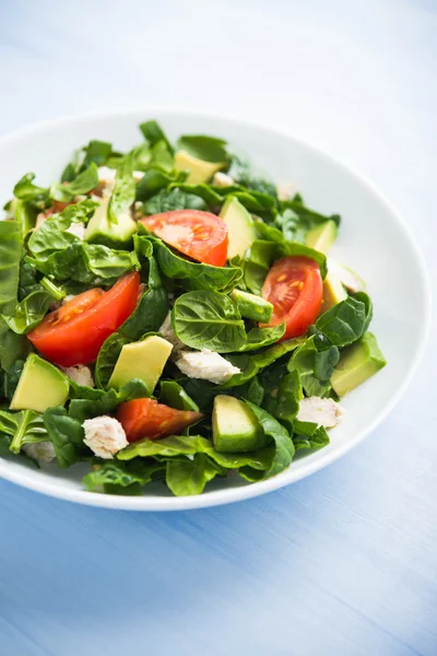 Salada saudável fresca com frango, tomate, espinafre e abacate em fundo de madeira azul close up — Fotografia de Stock