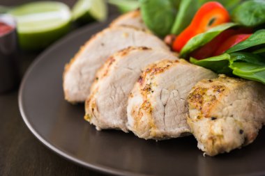 Kireç domuz eti bonfile salata koyu ahşap arka plan üzerinde yakın çekim sebze ile dilimlenmiş