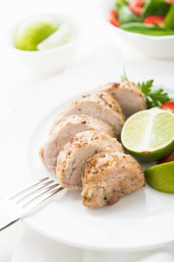 Beyaz arka plan üzerinde dilimlenmiş kireç domuz bonfile yakın