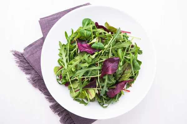 Salada fresca com verduras mistas (arugula, mesclun, mache) sobre fundo branco de madeira vista superior . — Fotografia de Stock