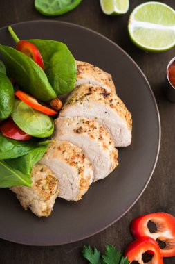 Kireç domuz eti bonfile salata koyu ahşap arka plan üzerinde yakın çekim sebze ile dilimlenmiş. 