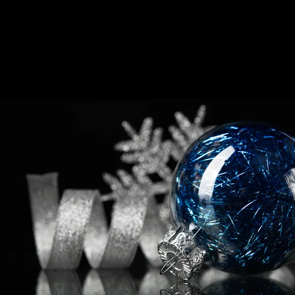 Siyah zemin üzerine mavi ve gümüş Noel süsleri — Stok fotoğraf