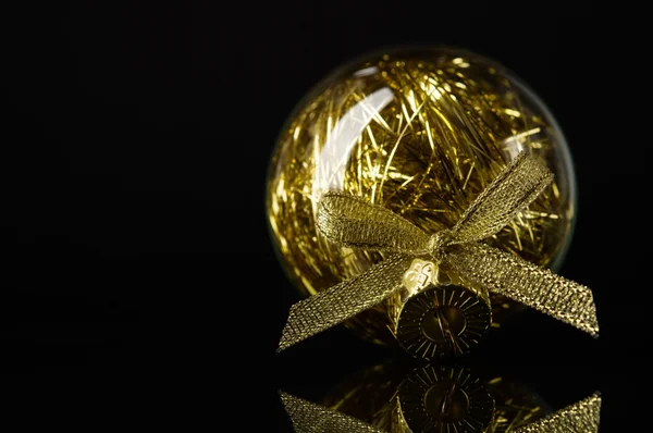 Golden xmas ball on black background with space for text — Stock Photo, Image