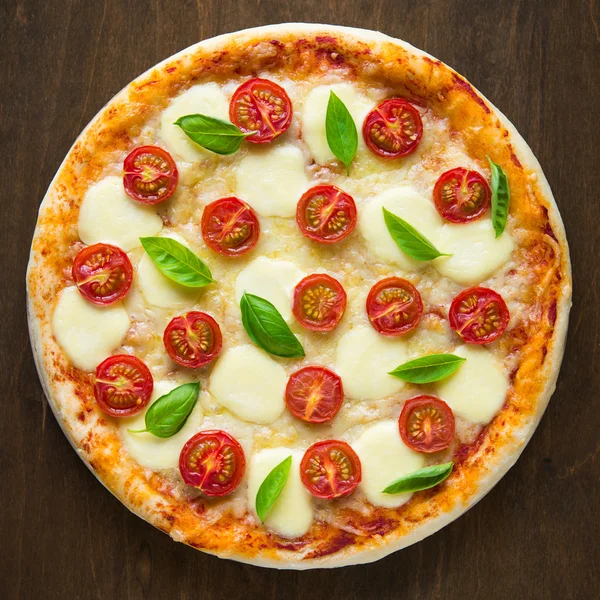 Pizza Margherita na tmavém dřevěném pozadí horní pohled — Stock fotografie