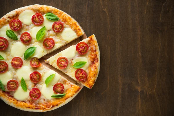 Pizza Margherita su sfondo in legno scuro vista dall'alto — Foto Stock