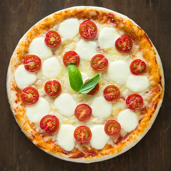 Pizza Margherita op donkere houten achtergrond bovenaanzicht — Stockfoto