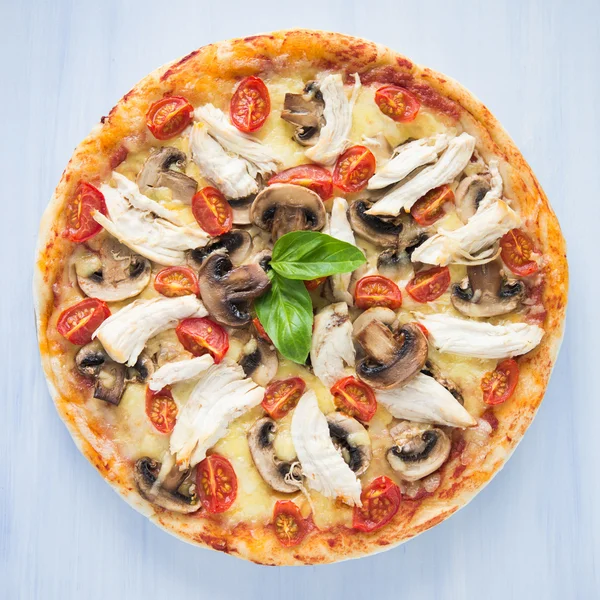 Pizza con pollo y champiñones sobre fondo azul vista superior — Foto de Stock