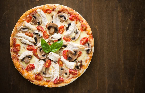 Pizza con pollo y champiñones sobre fondo de madera oscura con espacio para texto — Foto de Stock