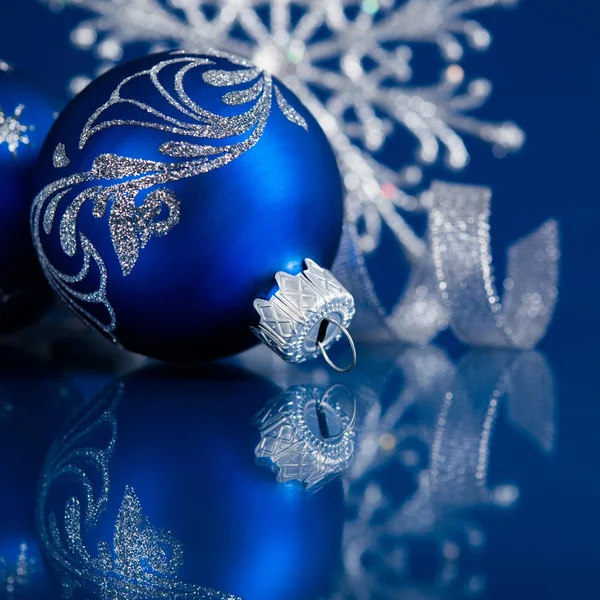Blå og sølv julepynt på mørkeblå juleretning med plass til tekst – stockfoto