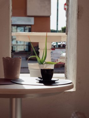 Yuvarlak Masa Üzerinde Siyah Kahve Kupası Pencere manzaralı Porto San Paolo, Sardunya, İtalya