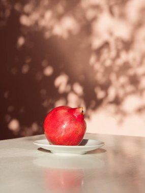 Beyaz Gövdede Olgun Nar Pastel Duvarında Çiçek Gölgeleri, Dikey Minimum Durgun Yaşam