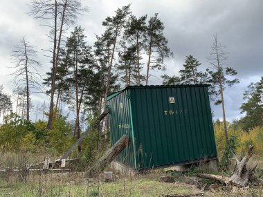 Ormandaki trafo kulübesi. Uzun ağaçların arka planında mini elektrik santrali. Doğanın ortasında demir bir ahır. Ormanda bir trafo kulübesi. Doğadaki mini elektrik santrali. Transformatör için metal yapı.