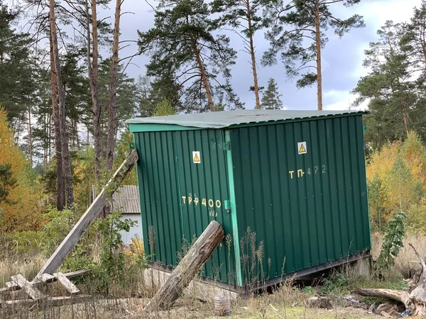 森の中の変圧器ブース 背の高い木の背景にあるミニ発電所 自然の中に鉄の納屋森の中の変圧器ブース 自然の中でミニ発電所 変圧器の金属構造 — ストック写真