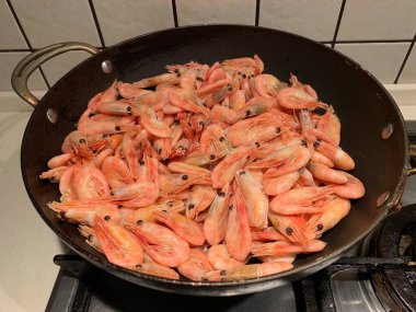 Soslu karides. Kızartma tavasında karides olan bir tabak. Baharatlı deniz ürünleri pişiriyorum..