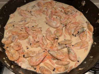 Soslu karides. Kızartma tavasında karides olan bir tabak. Baharatlı deniz ürünleri pişiriyorum..