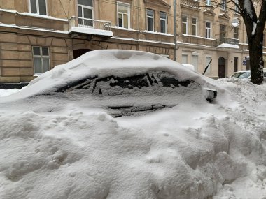 Araba otoparkta karla kaplıydı. Büyük bir kar tabakasının altında arabalar. Bir Avrupa şehrinin sokaklarına kar yağışı.