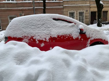 Araba otoparkta karla kaplıydı. Büyük bir kar tabakasının altında arabalar. Bir Avrupa şehrinin sokaklarına kar yağışı.
