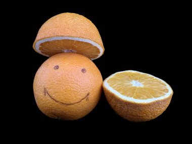 Olgun turuncu ve gülme şekli var. Sarı meyveler, bir bütün ve bir kesik halinde, siyah üzerine izole. Neşeli yüzlü bir citrus. Kavram: neşe, pozitif, gülümseme, mutluluk