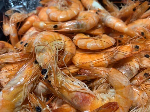 A large pile of boiled shrimp. Boiled yellow shrimps on a tray. Ready-to-cook seafood